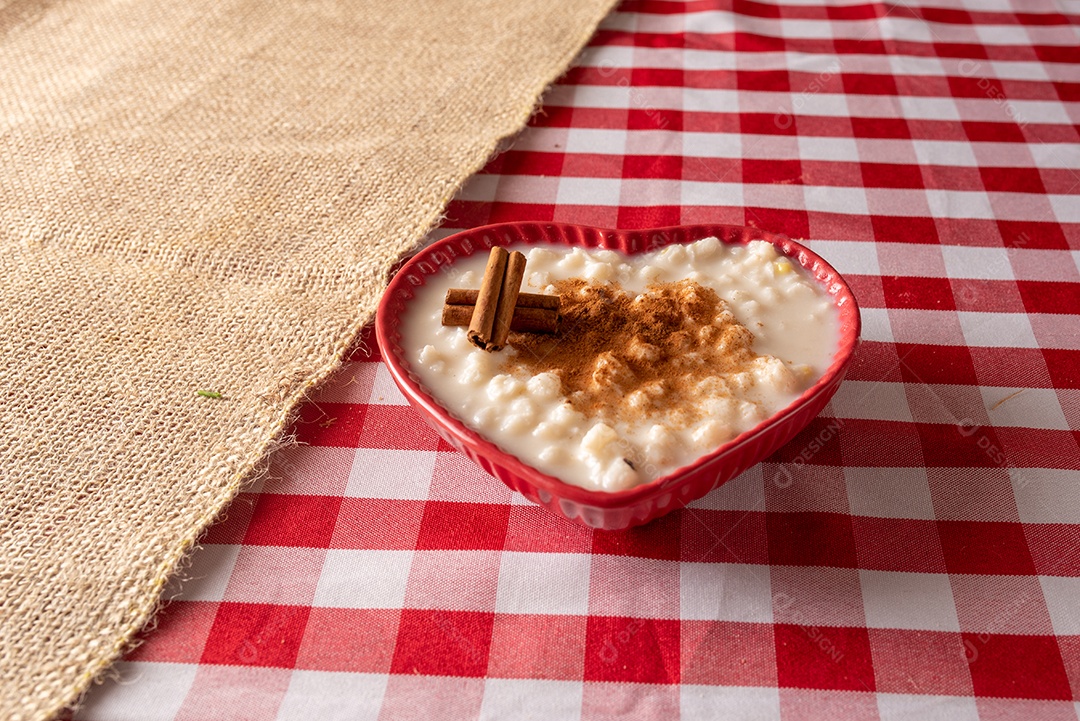 Mesa de madeira com comidas típicas da Festa Junina brasileira. espantalho