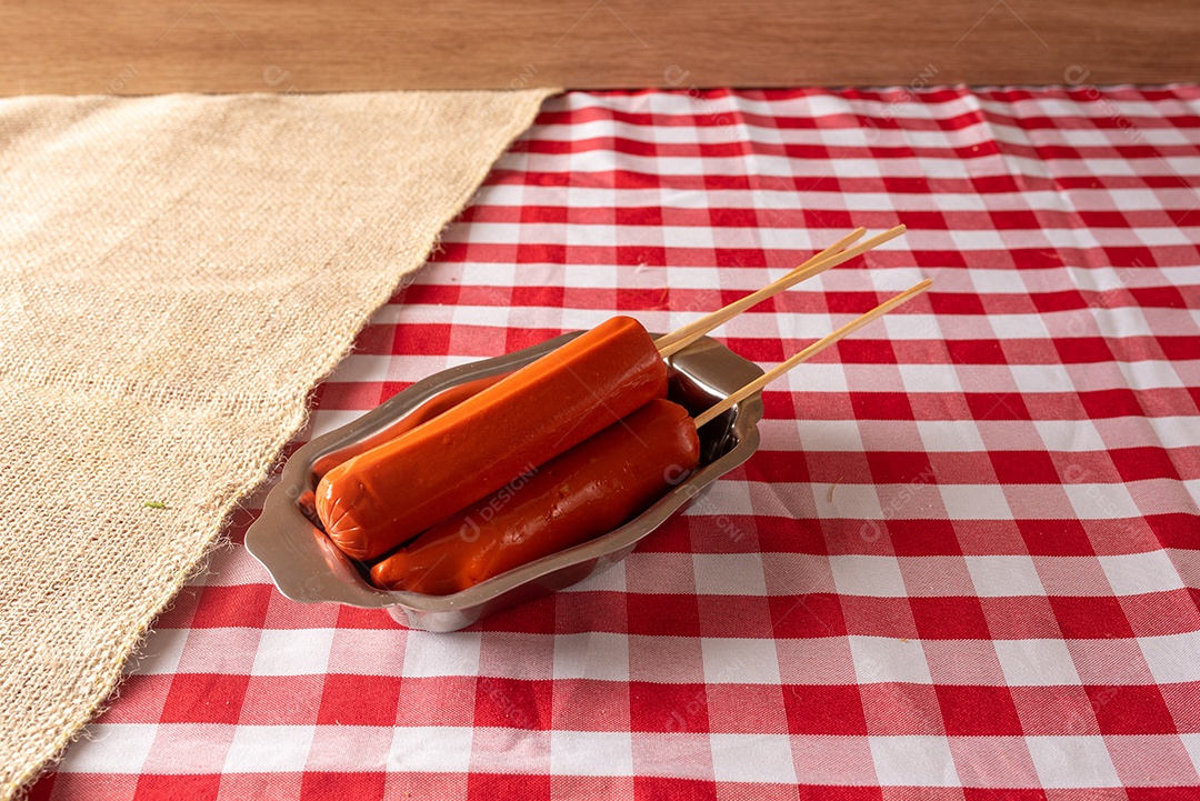 Mesa de madeira com comidas típicas da Festa Junina brasileira. espantalho