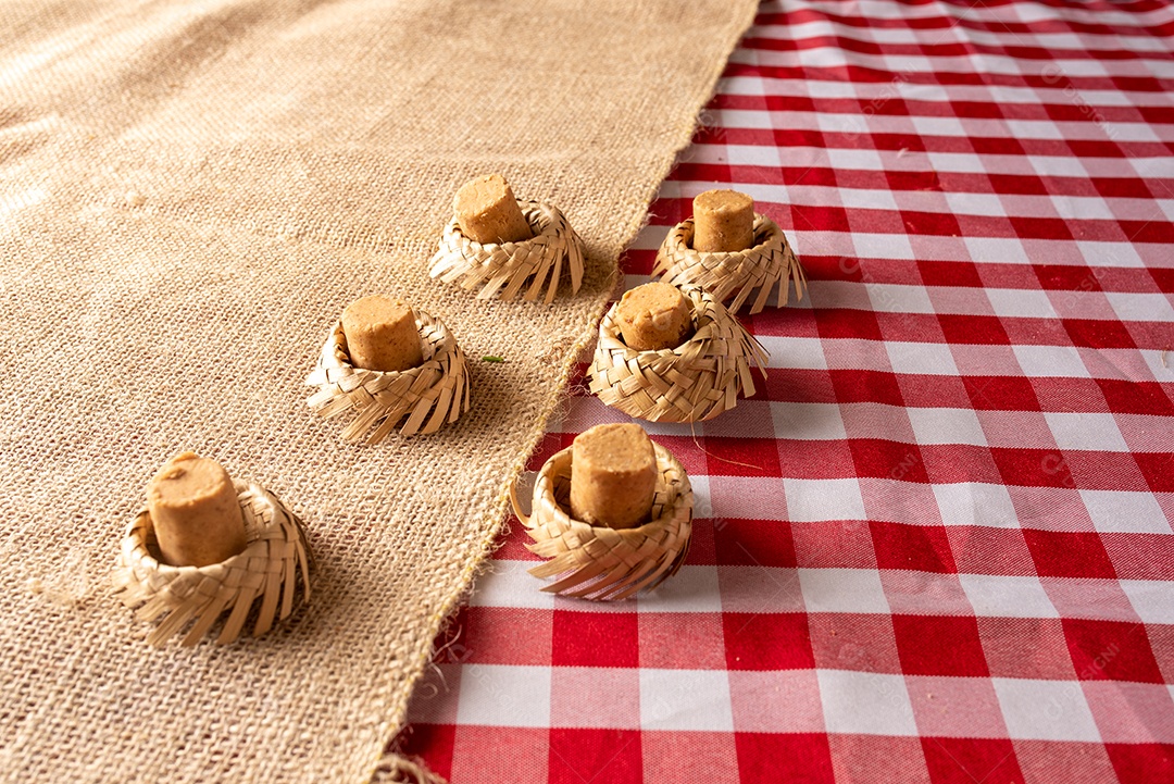 Mesa de madeira com comidas típicas da Festa Junina brasileira. espantalho
