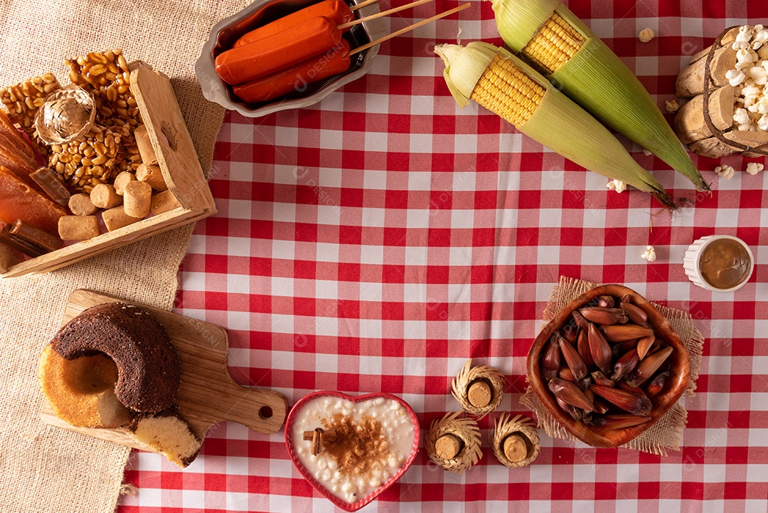 Mesa de madeira com comidas típicas da Festa Junina brasileira. espantalho