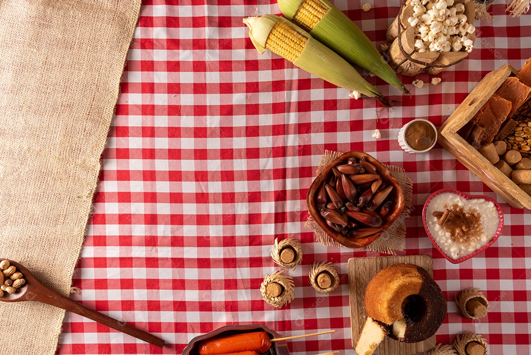 Mesa de madeira com comidas típicas da Festa Junina brasileira. espantalho