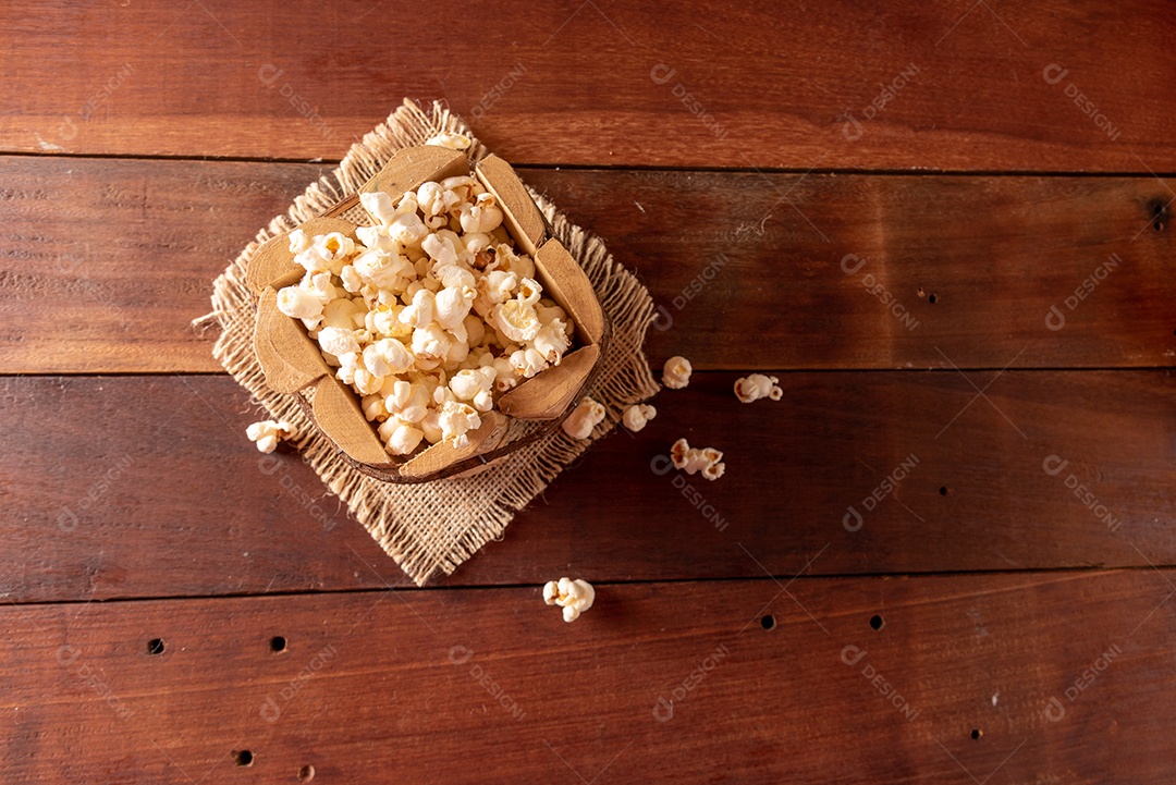 Mesa de madeira com comidas típicas da Festa Junina brasileira. espantalho
