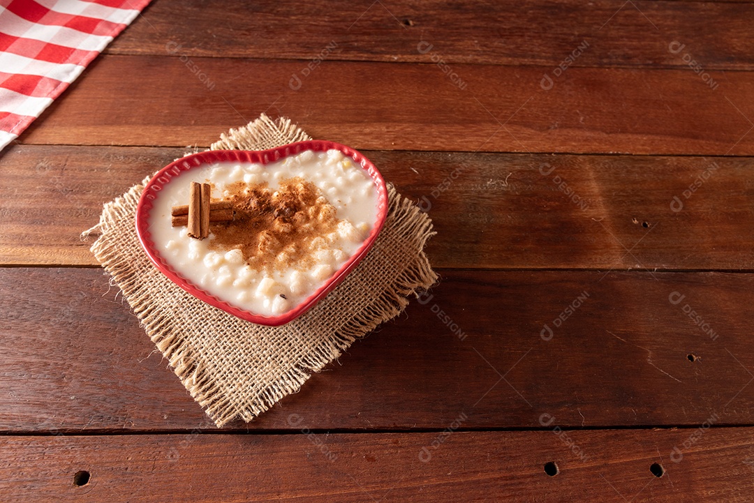Mesa de madeira com comidas típicas da Festa Junina brasileira. espantalho