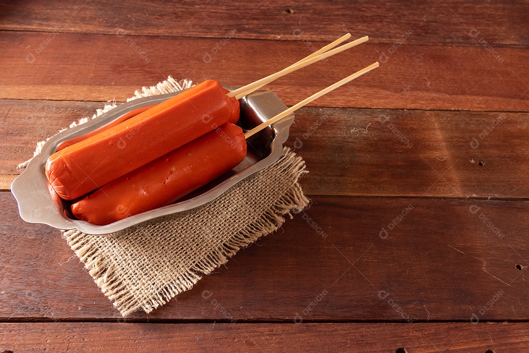 Mesa de madeira com comidas típicas da Festa Junina brasileira. espantalho