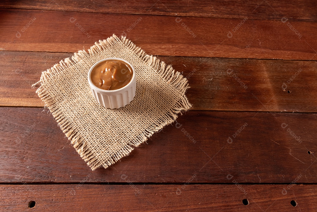 Mesa de madeira com comidas típicas da Festa Junina brasileira. espantalho