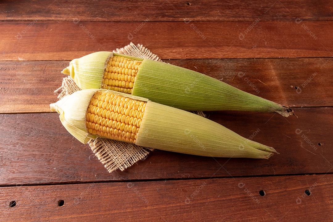Mesa de madeira com comidas típicas da Festa Junina brasileira. espantalho