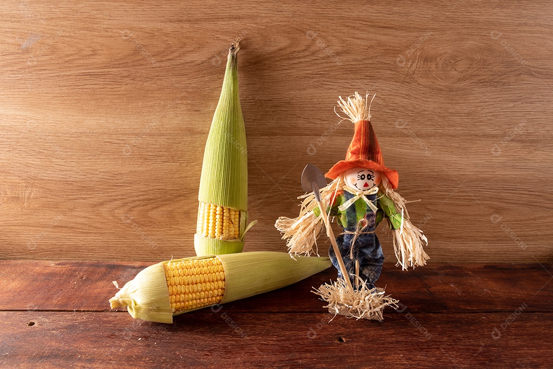 Mesa de madeira com comidas típicas da Festa Junina brasileira. espantalho