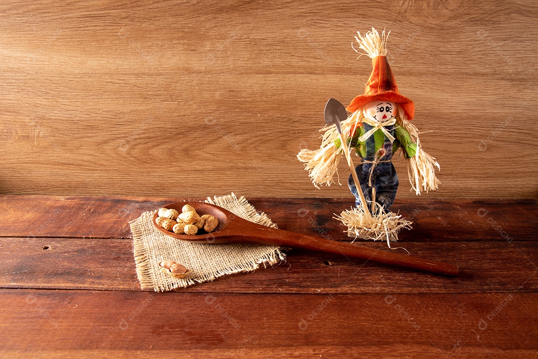 Mesa de madeira com comidas típicas da Festa Junina brasileira. espantalho