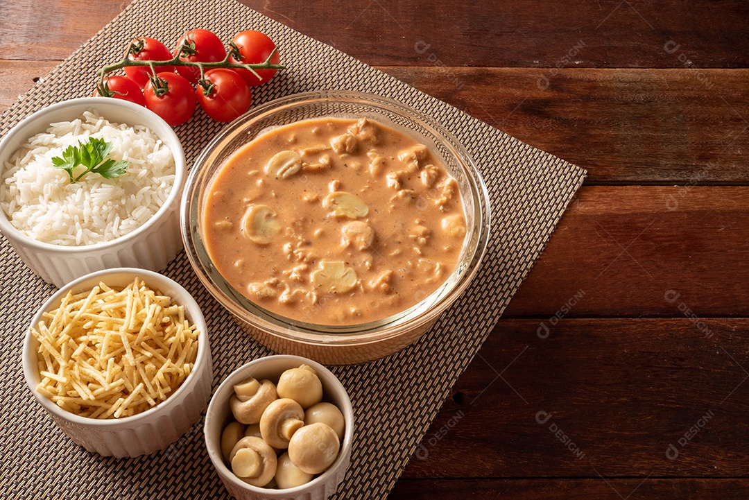 Strogonoff de frango acompanhado de arroz, salada e batata palha.