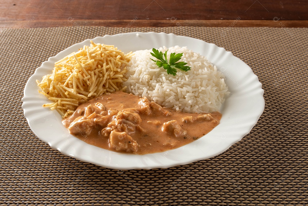 Strogonoff de frango acompanhado de arroz, salada e batata palha.