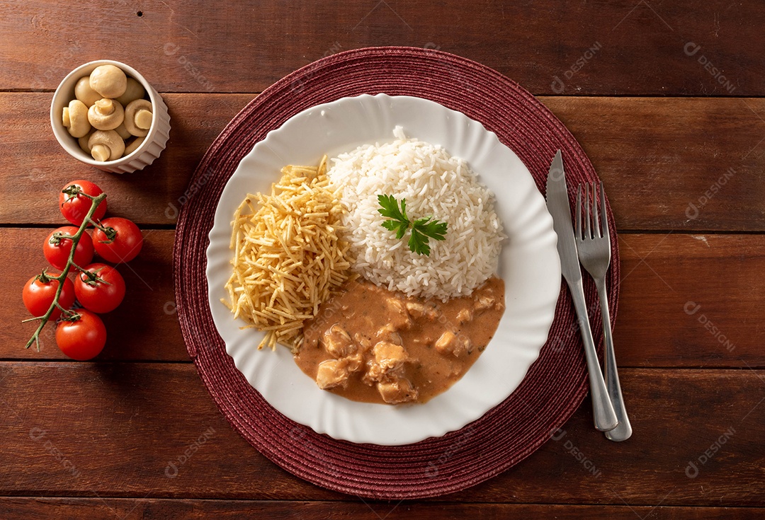 Strogonoff de frango acompanhado de arroz, salada e batata palha.