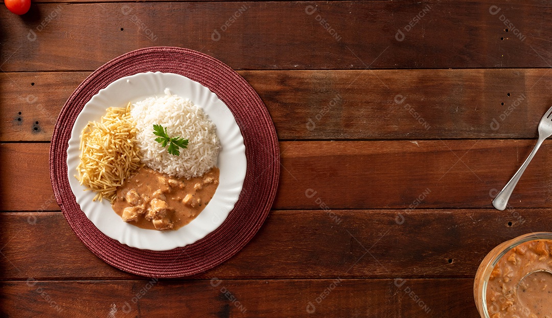 Strogonoff de frango acompanhado de arroz, salada e batata palha.