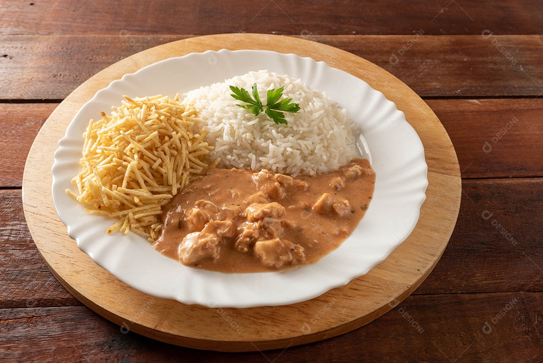 Strogonoff de frango acompanhado de arroz, salada e batata palha.