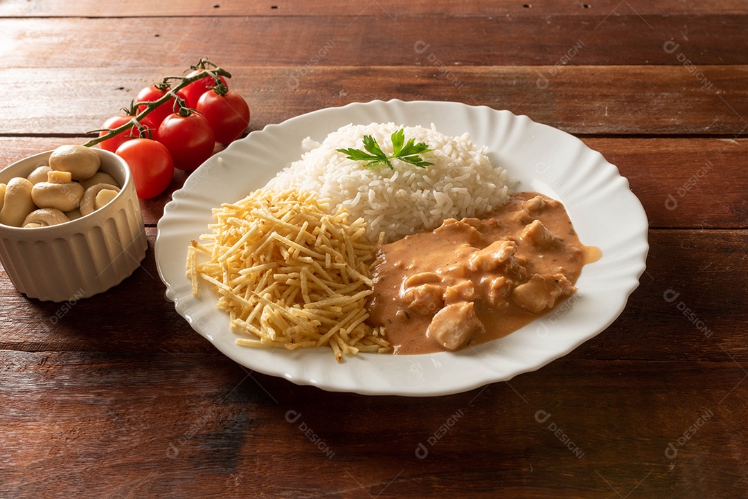 Strogonoff de frango acompanhado de arroz, salada e batata palha.
