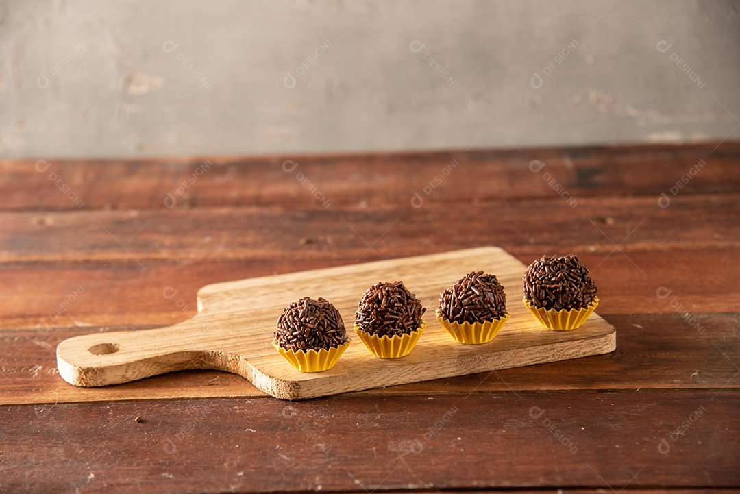 Brigadeiro (Brigadeiro) Doce tradicional brasileiro. Alinhado em uma placa de madeira