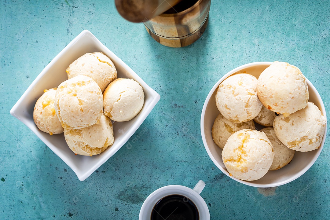 Delicioso pão de queijo, prato típico brasileiro, sobre uma mesa com fundo verde e parede branca.