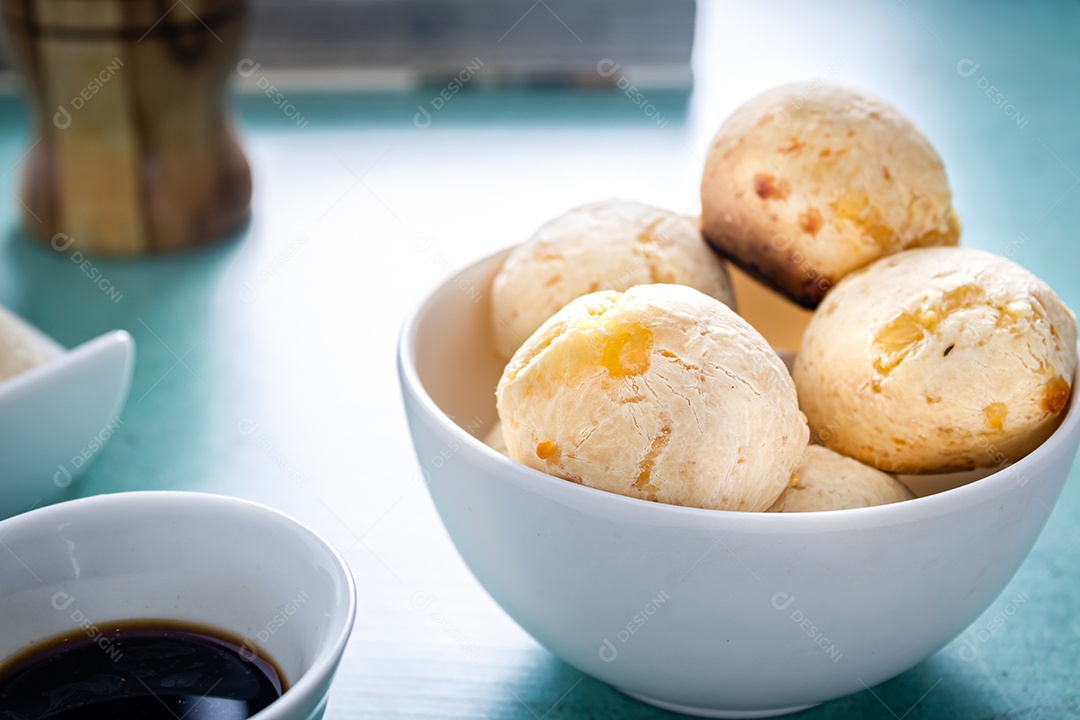 Delicioso pão de queijo, prato típico brasileiro, sobre uma mesa com fundo verde e parede branca.