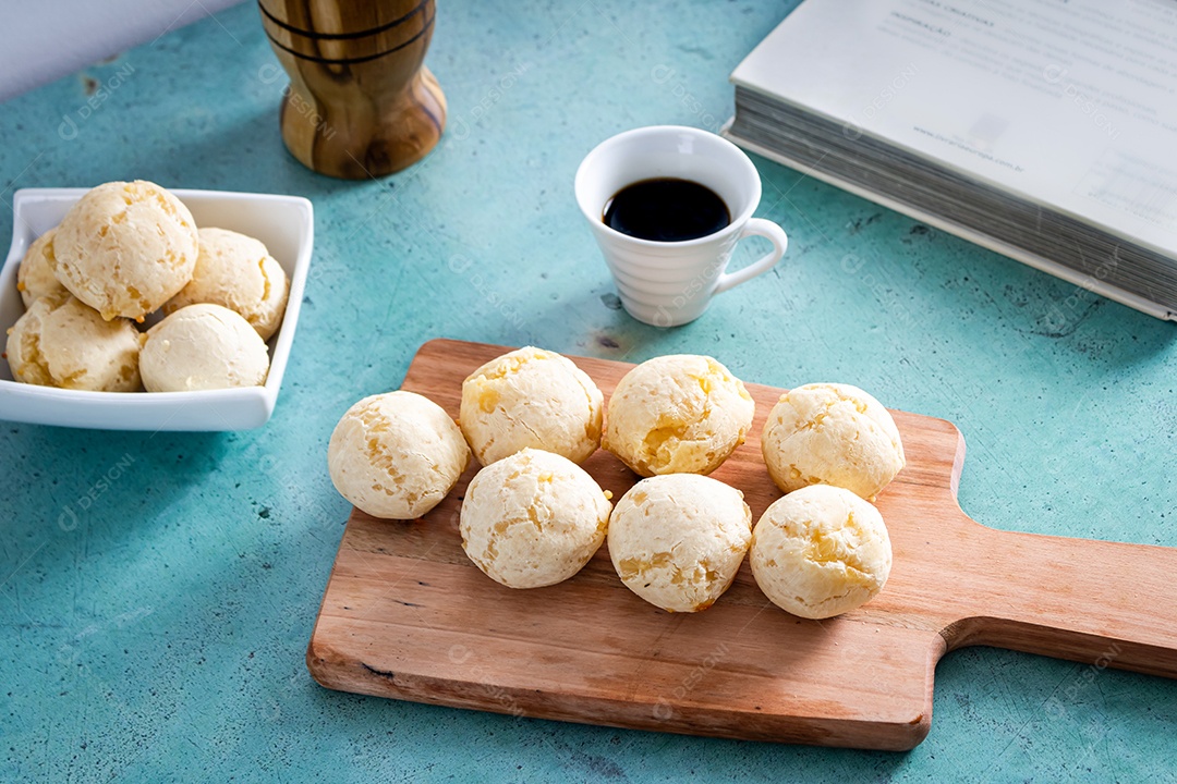 Delicioso pão de queijo, prato típico brasileiro, sobre uma mesa com fundo verde e parede branca.