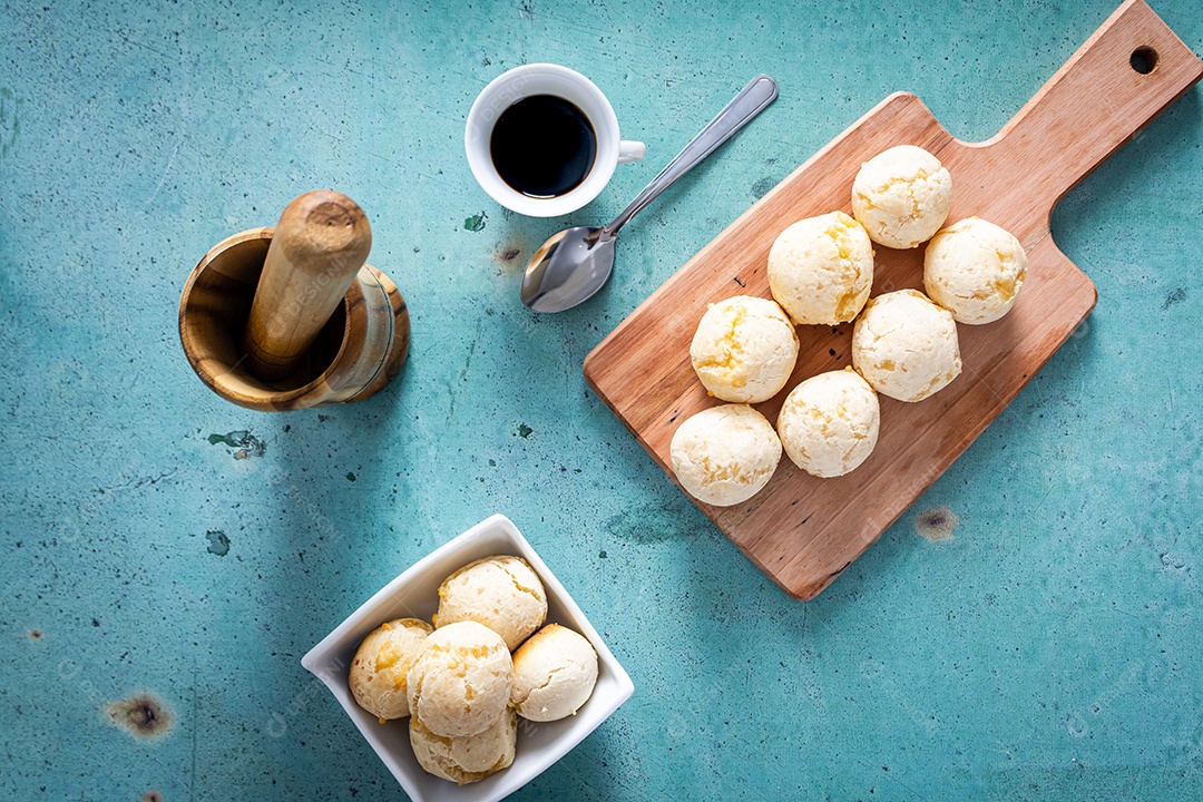 Delicioso pão de queijo, prato típico brasileiro, sobre uma mesa com fundo verde e parede branca.
