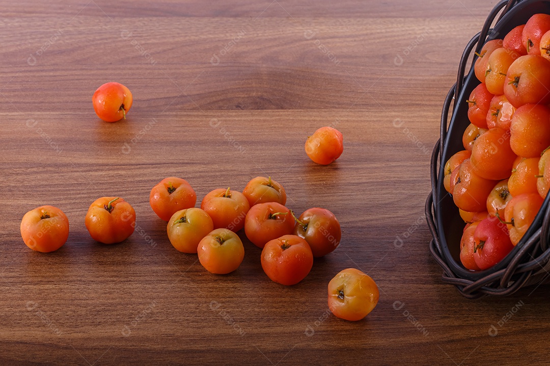 Pote preto com acerolas na mesa
