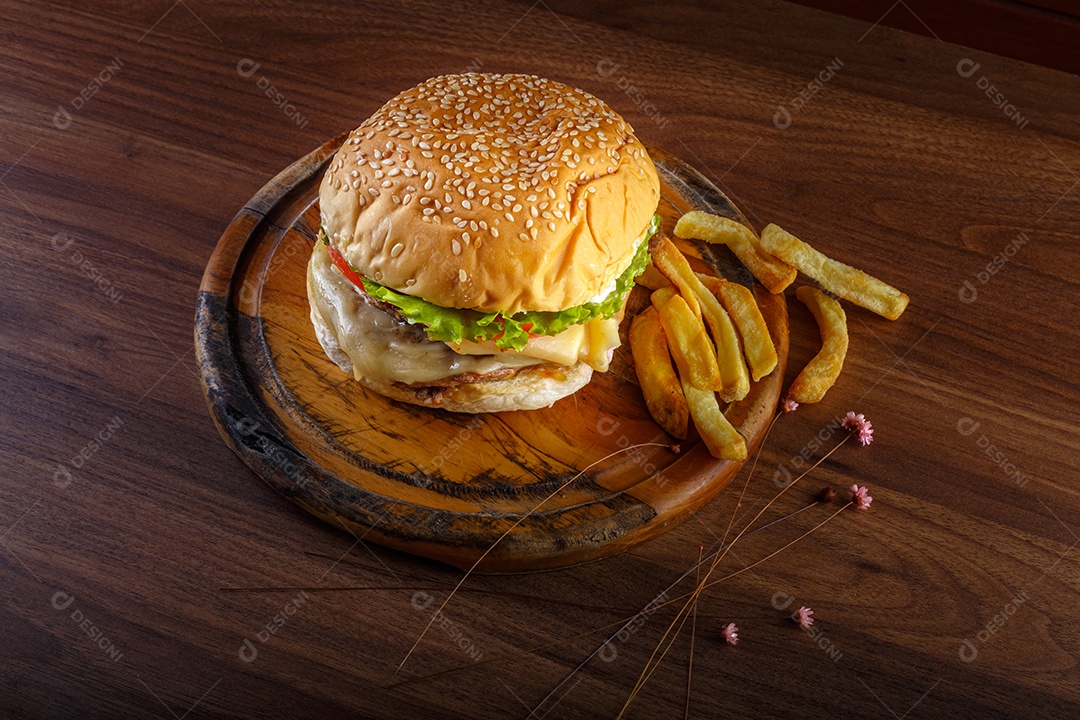 Delicioso hambúrguer com batatas fritas na mesa de madeira.