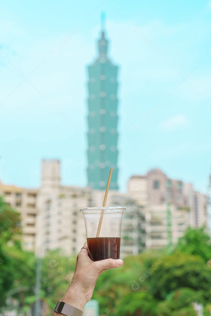 Mão de uma mulher segurando um copo de café gelado contra o fundo da cidade de Taipei