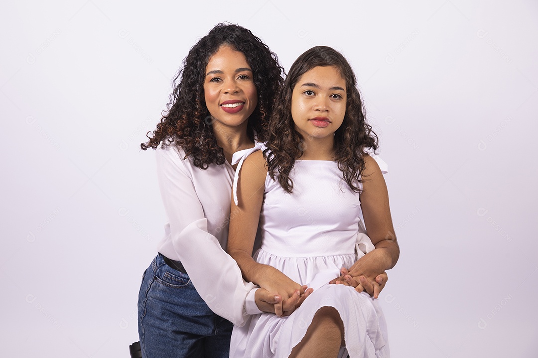 Linda mulher jovem mãe ao lado de sua filha sobre fundo isolado