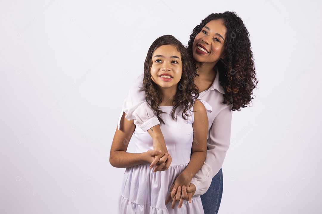 Linda mulher jovem mãe ao lado de sua filha sobre fundo isolado