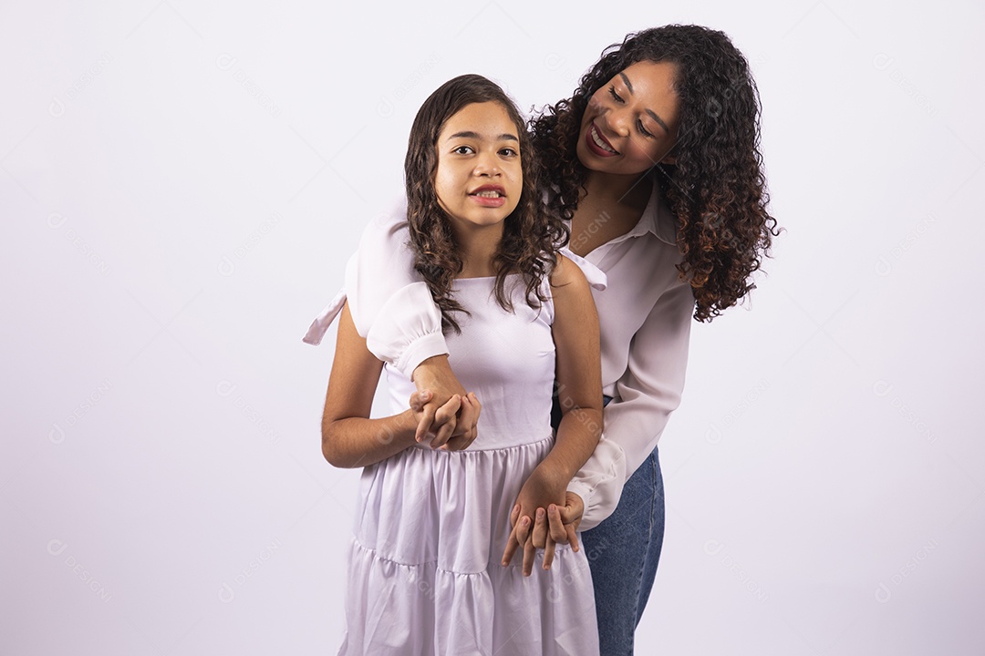 Linda mulher jovem mãe ao lado de sua filha sobre fundo isolado