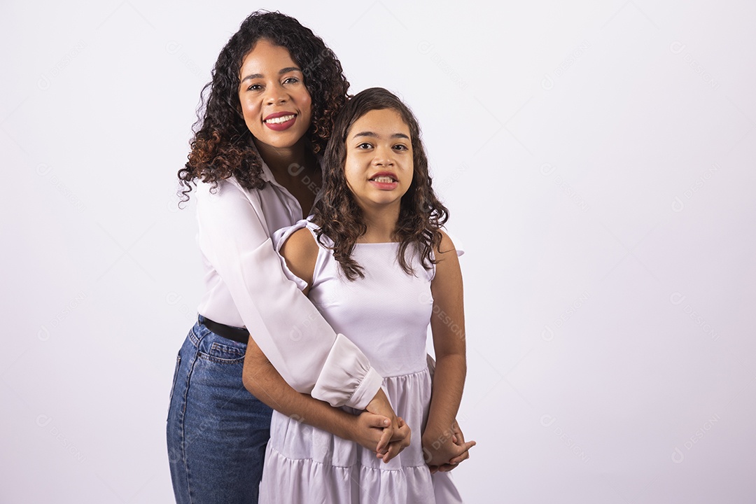 Linda mulher jovem mãe ao lado de sua filha sobre fundo isolado