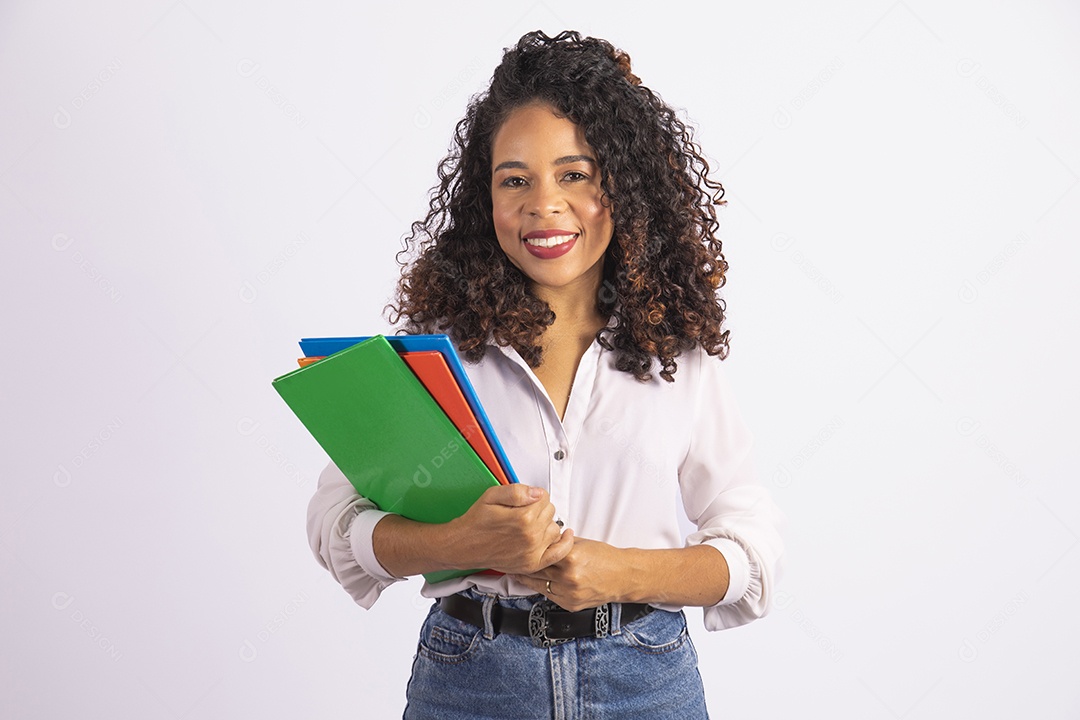 Linda mulher jovem cabelo cacheado segurando material escolar sobre fundo isolado