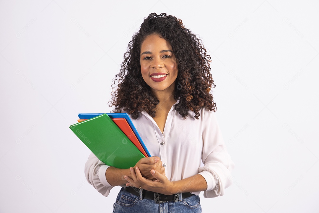 Linda mulher jovem cabelo cacheado segurando material escolar sobre fundo isolado