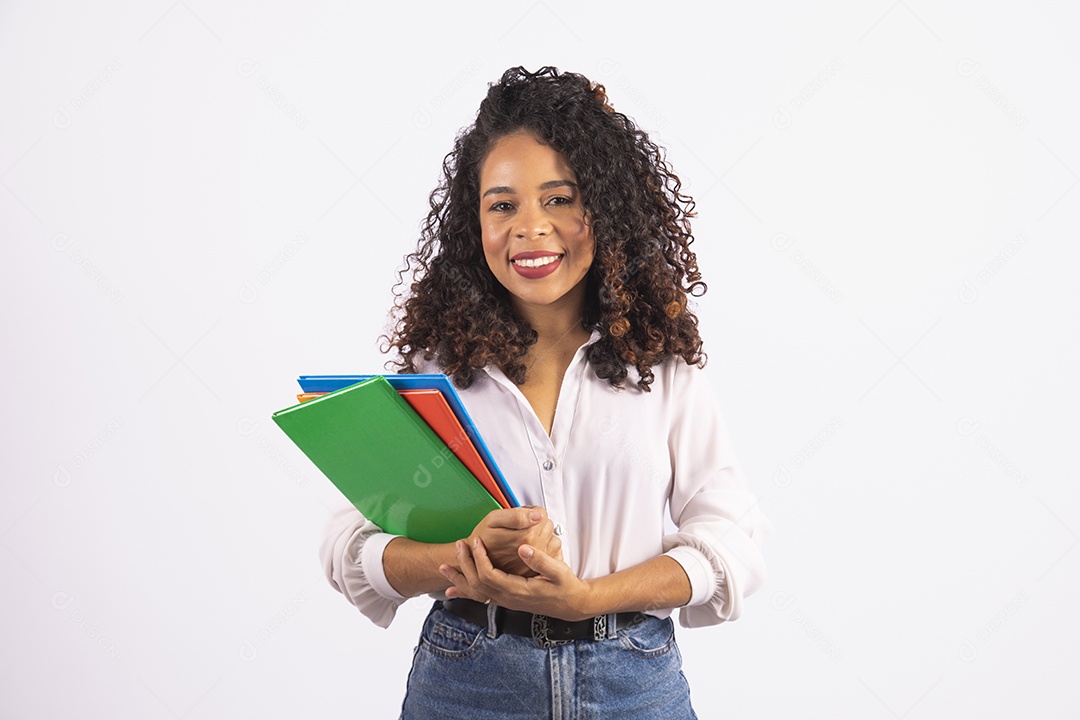 Linda mulher jovem cabelo cacheado segurando material escolar sobre fundo isolado