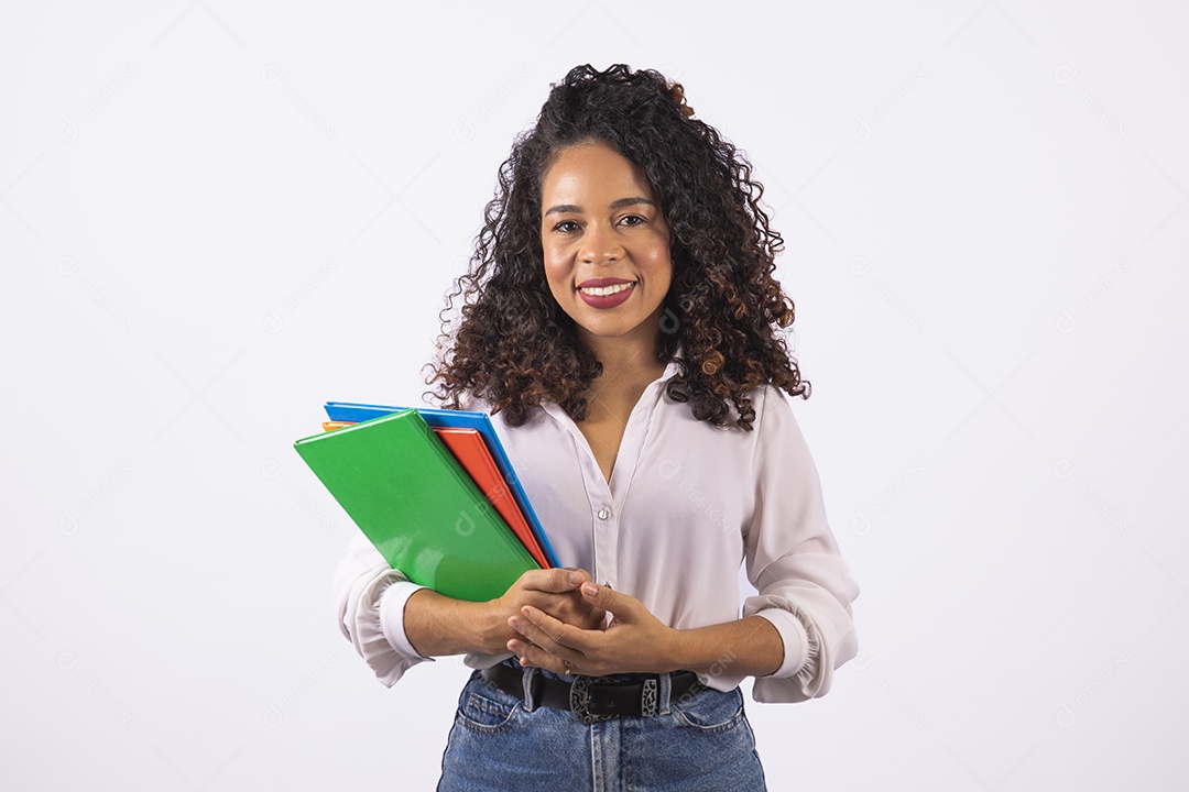 Linda mulher jovem cabelo cacheado segurando material escolar sobre fundo isolado