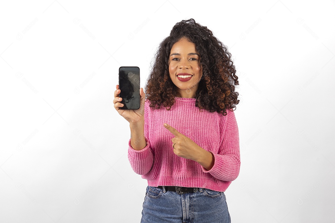 Linda mulher jovem cabelo cacheado segurando celular smartphone sobre fundo isolado branco