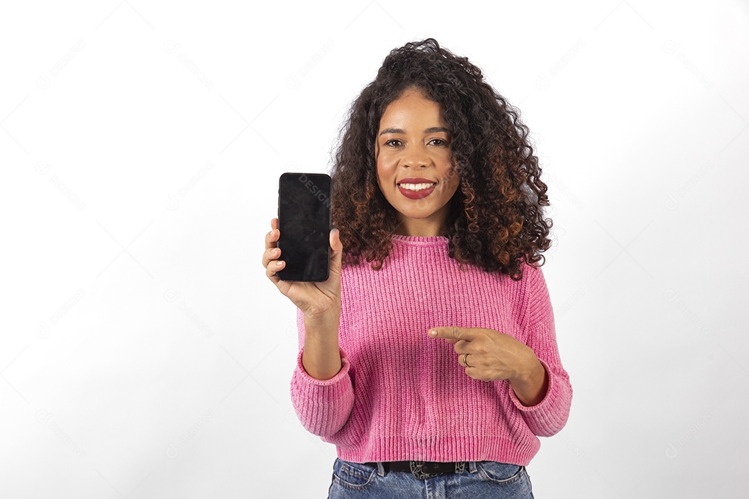 Linda mulher jovem cabelo cacheado segurando celular smartphone sobre fundo isolado branco