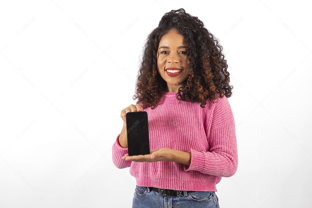 Linda mulher jovem cabelo cacheado segurando celular smartphone sobre fundo isolado branco