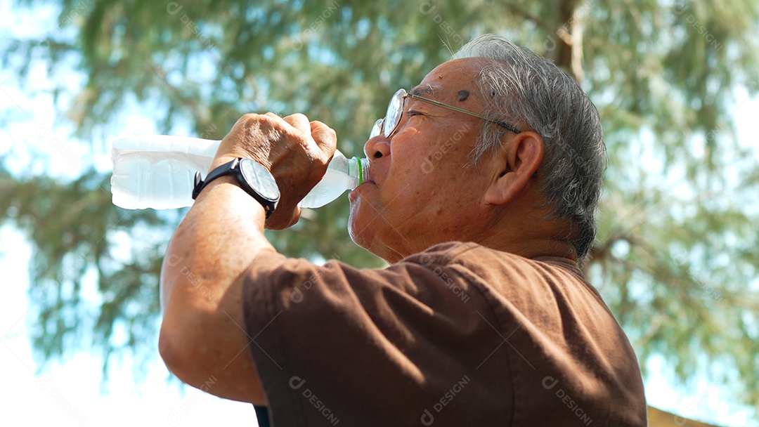 Feliz idoso asiático bebendo água