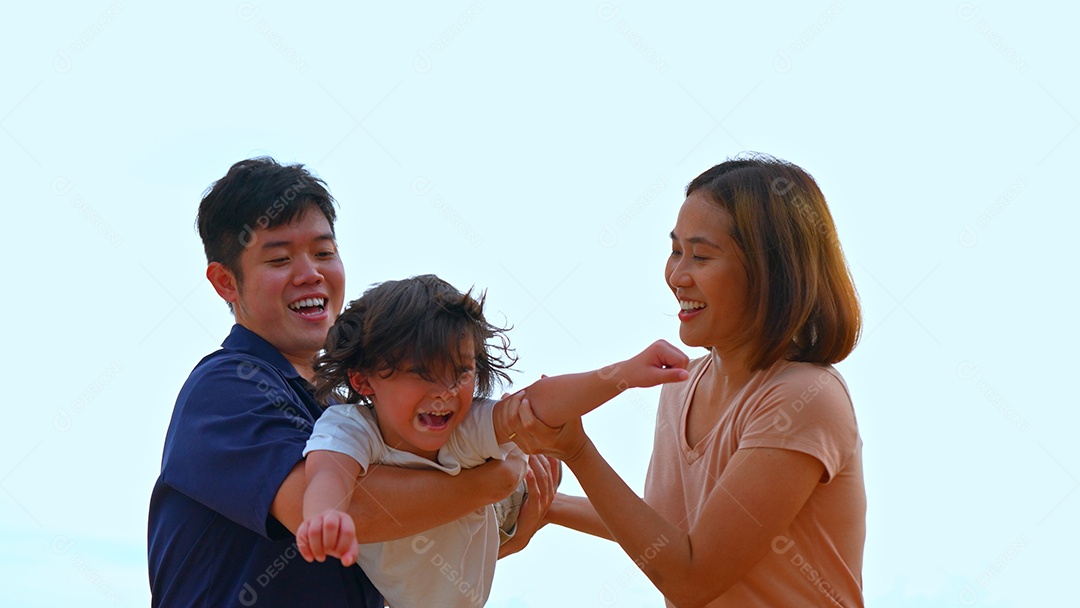 Família feliz de pai e mãe carregando filho voando brincar lá fora na praia juntos