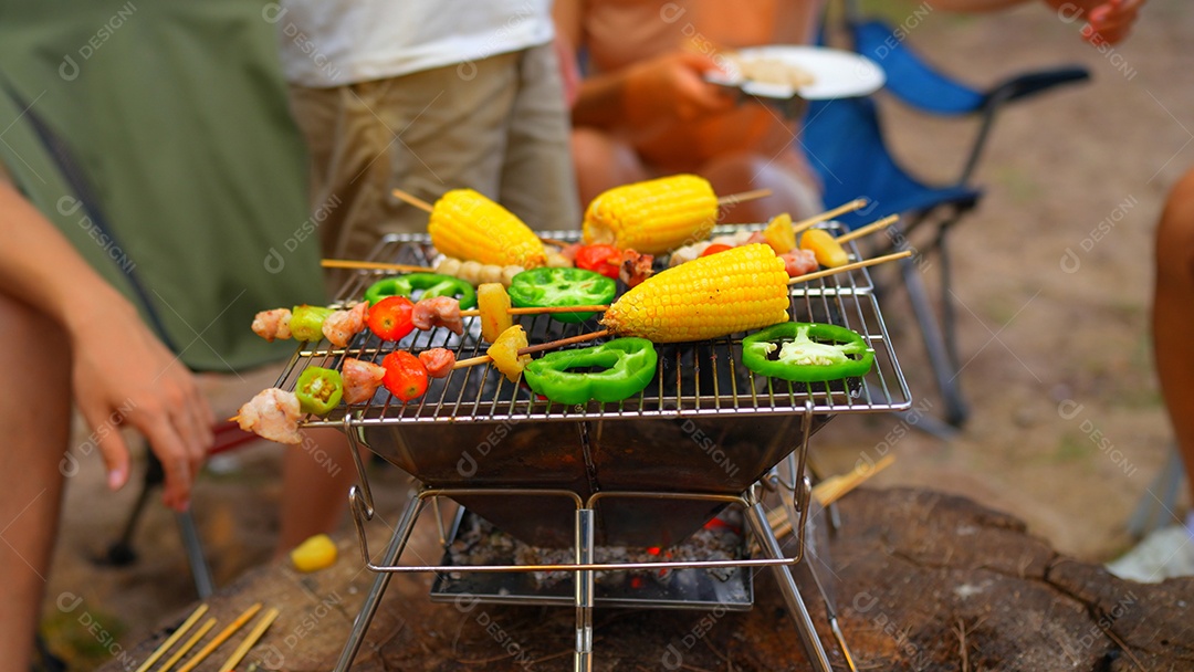 Mãos da família feliz comendo churrasco juntos