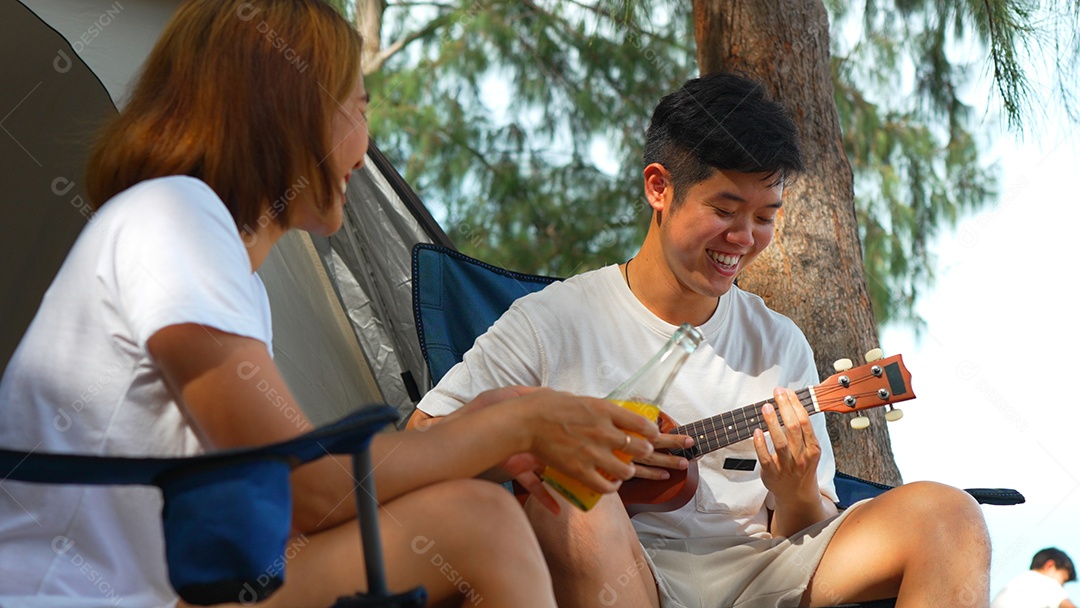 Casal asiático curtindo juntos acampar na praia