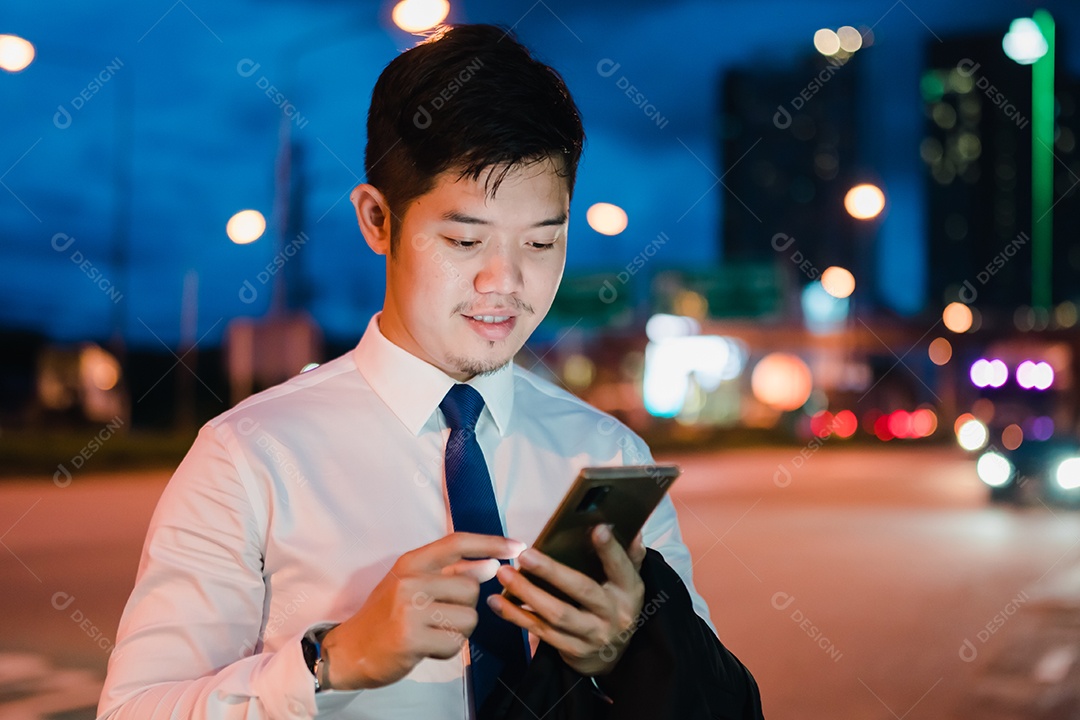 Empresário asiático usa telefone celular, smartphone depois do trabalho andando pela rua da cidade