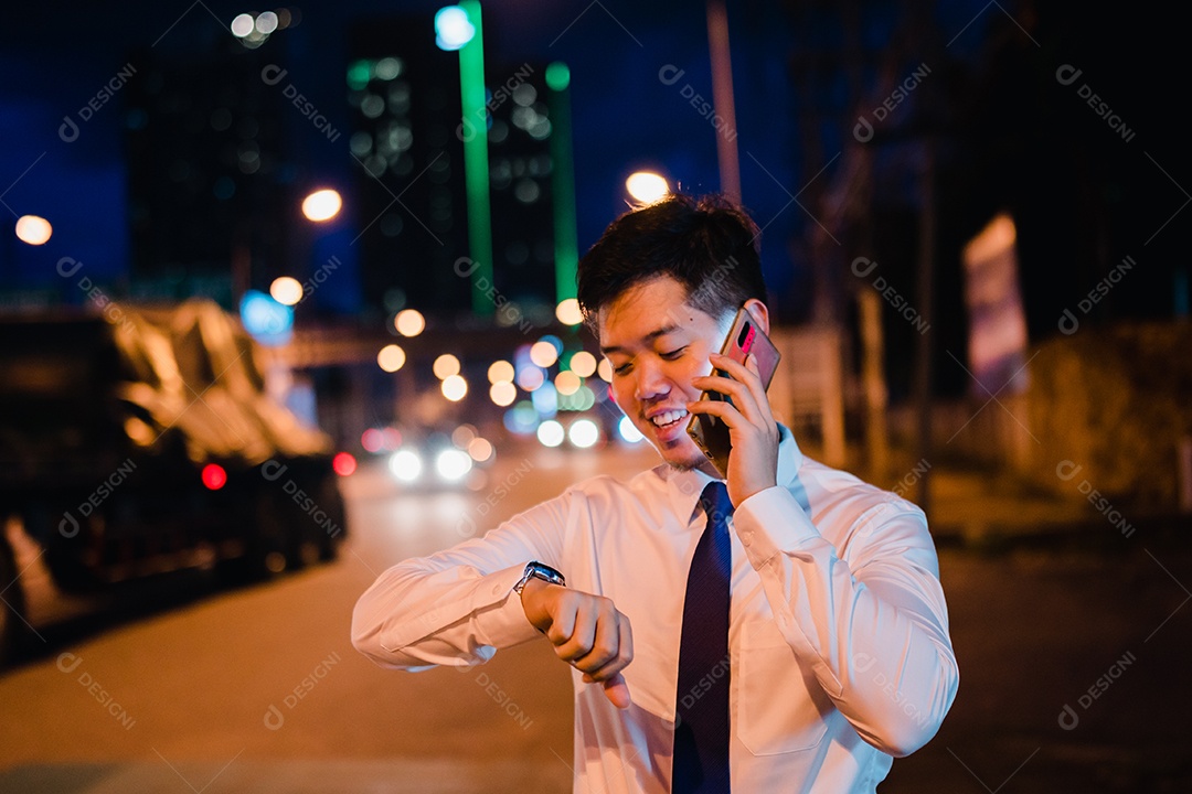 Empresário asiático usa telefone celular, smartphone depois do trabalho andando pela rua da cidade