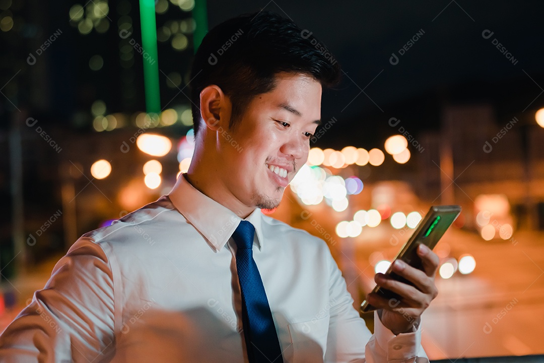 Empresário asiático usa telefone celular, smartphone depois do trabalho andando pela rua da cidade