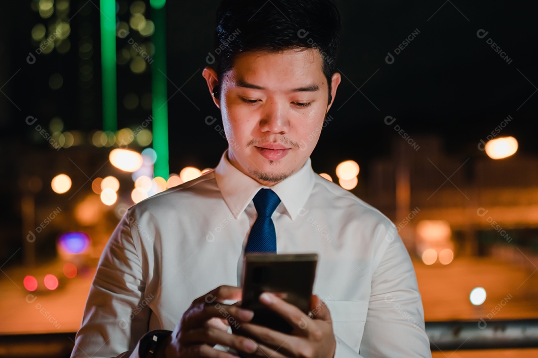 Empresário asiático usa telefone celular, smartphone depois do trabalho andando pela rua da cidade