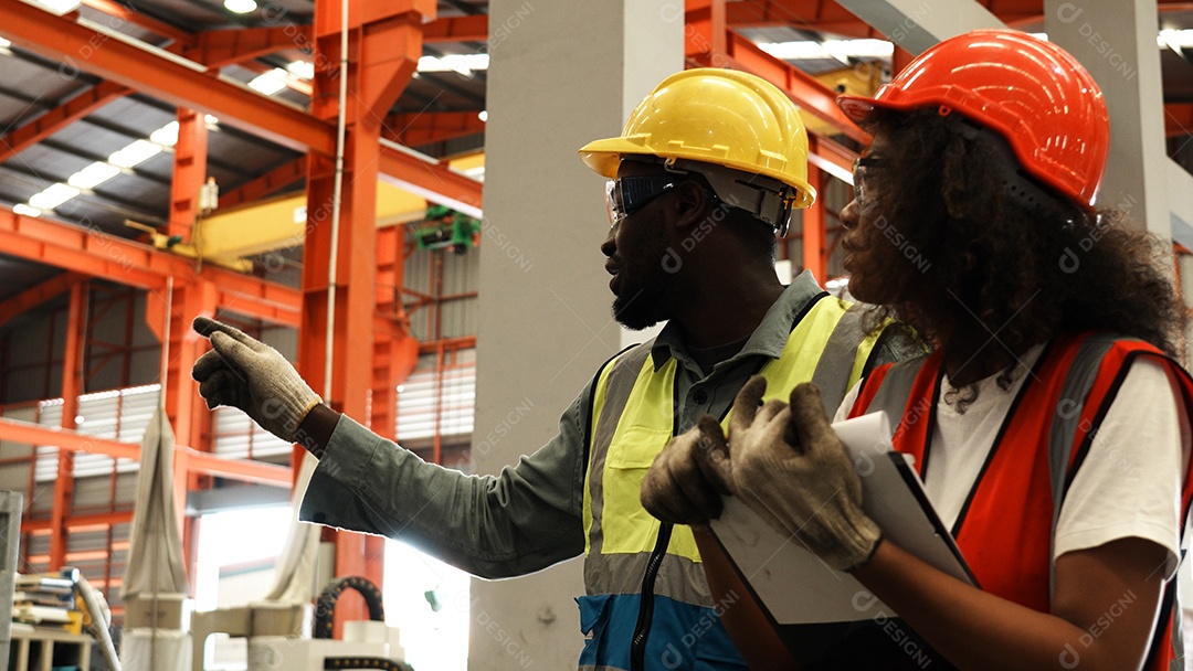 Engenheiros industriais pesados ​​estão juntos em uma fábrica de aço.
