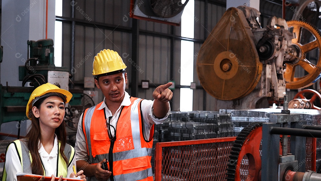 Engenheiros industriais pesados ​​estão juntos em uma fábrica de aço.