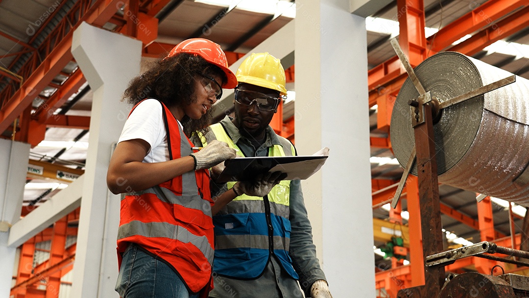 Engenheiros industriais pesados ​​estão juntos em uma fábrica de aço.