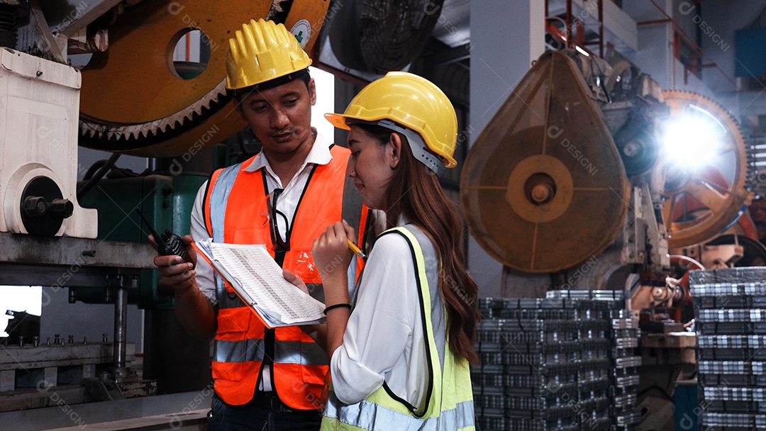 Dois engenheiros industriais pesados ​​verificam juntos em uma fábrica de aço.