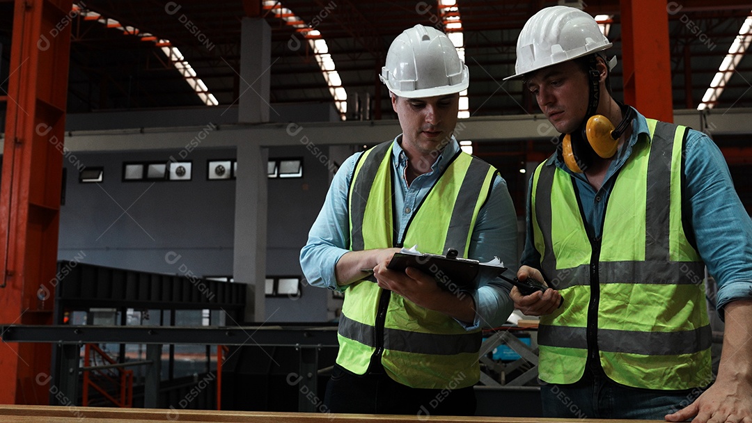Engenheiros industriais pesados ​​estão juntos em uma fábrica de aço.